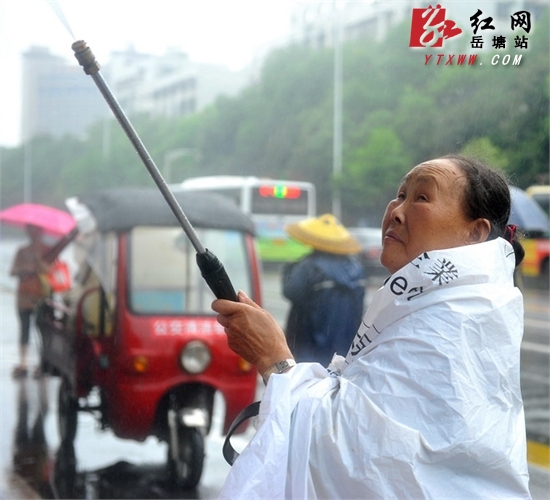 这是我们的工作 六旬广告清洁工暴雨中的坚守