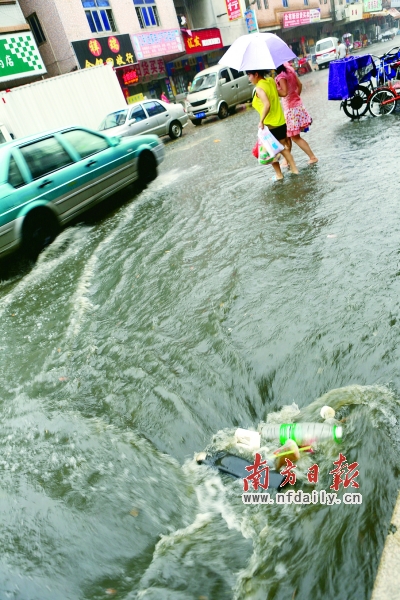 昨日下午，东莞市大朗镇富华中路，暴雨突袭，路人被雨淋得狼狈不堪，路面有一定的积水。苏仕日 摄