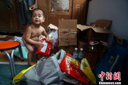 “饥饿娃娃”常笑在姥爷的手里显得非常娇小 周小云 摄