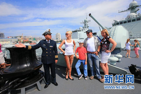7月6日，在俄罗斯符拉迪沃斯托克港，中国海军舰员向当地民众介绍开放的中国军舰。