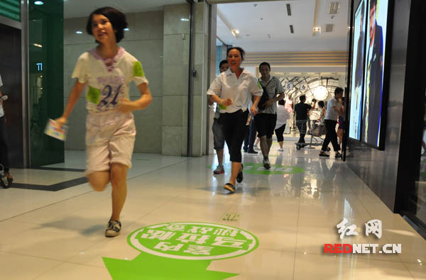 参赛选手奋力跑过由商铺通道设计成的马拉松赛道。