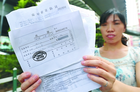 昨日，杨家坪，代女士出示中介公司向她收取的“继承个人所得税”的部分收据。