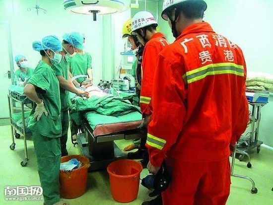 在手术室里，医生和消防人员对小男孩联合施救。杨鸿升 摄