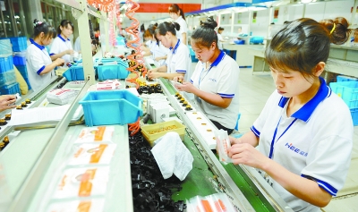 7月12日,位于长沙市芙蓉区的湖南省豪意电器有限公司,工人在组装新型开关插座。本报记者徐行摄