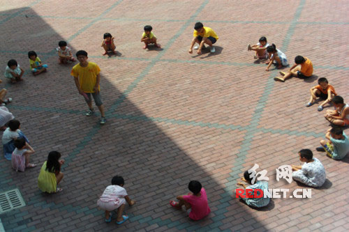 体育课上，学生和老师一起开心地玩丢手绢游戏