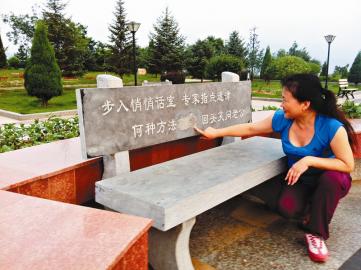 一位市民在涂抹过的石凳前，仔细辨认字迹。