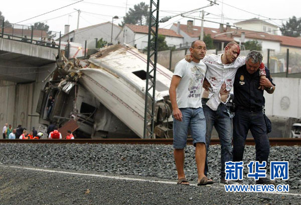 7月24日，在西班牙西北部加利西亚自治区首府圣地亚哥－德孔波斯特拉附近，救援人员和当地居民从脱轨列车中救出一名受伤乘客。
