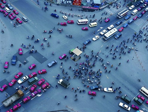 有些行人过马路根本不看红绿灯，凑一撮就走，人车混行隐患多（资料片）