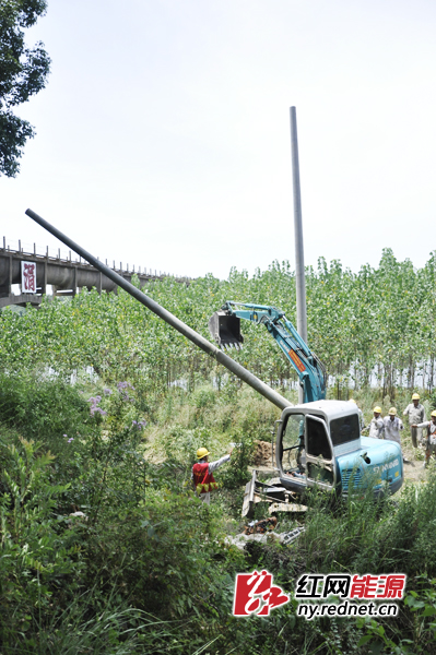 8月2日正午，湘潭县射埠镇供电所在涓水边立杆。为了引涓水到邻近的村，这里要新增一个变电台区，需要安装一台100KV变压器，立电杆7根。
