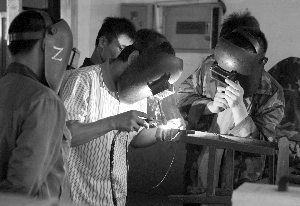在山东蓝翔高级技工学校，几名电气焊专业的学生在进行实践操作