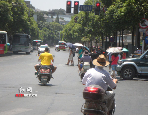 中午11:30，长沙麓山路和新民路交叉路口三辆电动车无视亮着的红灯疾驶而过。