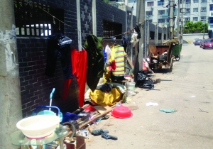 违建房对面的墙角下堆放着杂物
