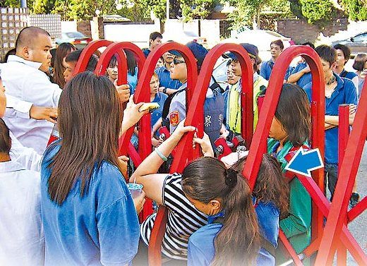 杯王潘庆瑞夺回经营权后封厂清点，其妻陈丽杏（箭头处）钻进铁卷门内要求开门。图自台媒