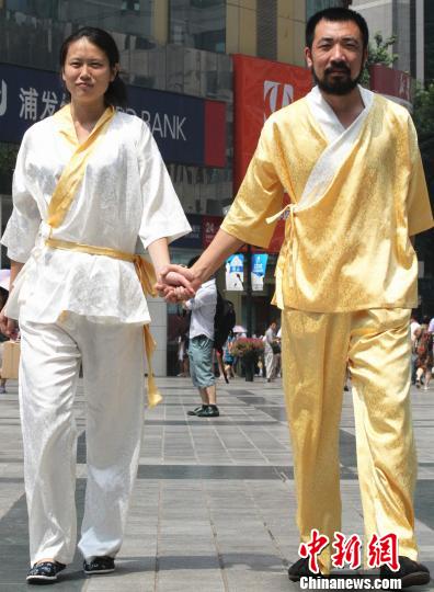 一对情侣身着汉服套装，手牵手在街上行走。 周毅 摄