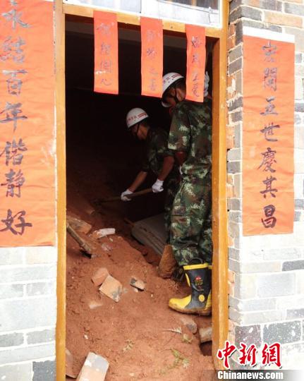图为消防官兵进入事发民宅搜救被埋人员。　王奎　摄