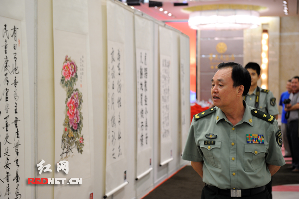 湖南省军区司令员黄跃进正在欣赏展出的书画作品。