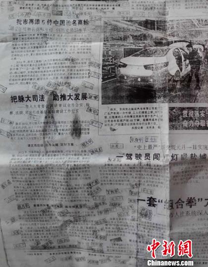 村民在这张报纸上发现自己被刻章。 谷华 摄