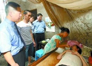 20日,检察官来到刘宗玲(右二)家回访,并看望她瘫痪的父亲。 重庆晨报记者 李斌 摄