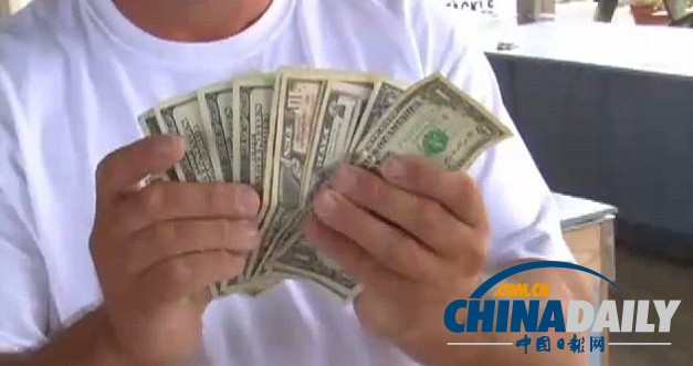 一名民众捡到一些美元。