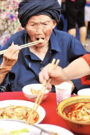 8月25日，116岁付素清婆婆在生日宴上吃肉。