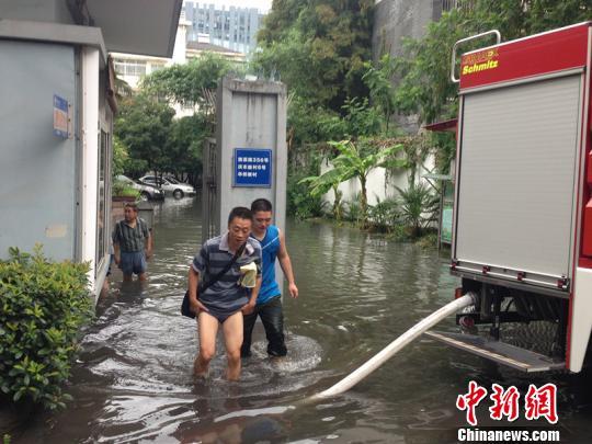 图为行人卷起裤腿趟水出入。　来明　摄