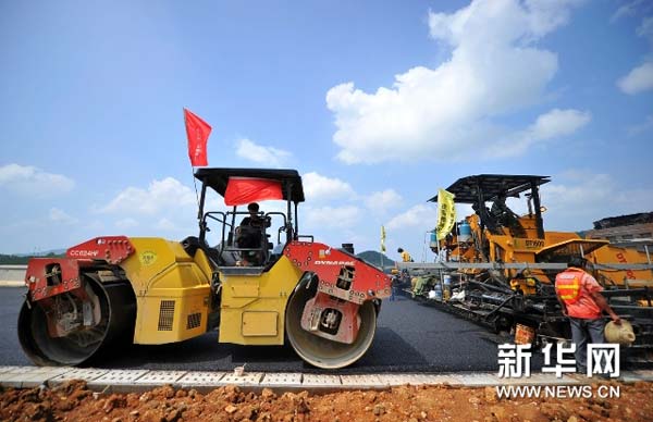 8月26日,公路施工人员正在张花高速公路三家馆互通区主线桥上进行沥青