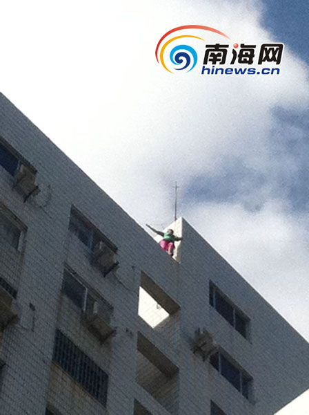 女子站在三亚市政府第二办公楼15楼楼顶(南海网记者马伟元摄)