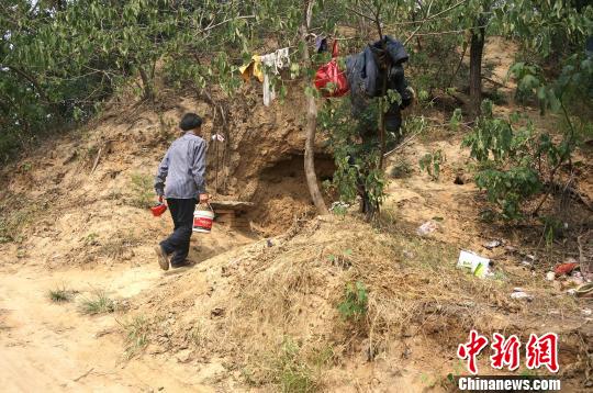 图为被网友称为“城外人”的男子走出洞穴。 周小云 摄