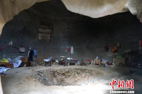 图为被网友称为“城外人”的男子走出洞穴。 周小云 摄