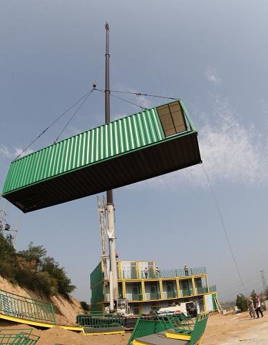 　9月14日，在烟台市莱山区朱雀山生态旅游度假区，施工人员在吊装集装箱。新华社发（申吉忠 摄）
