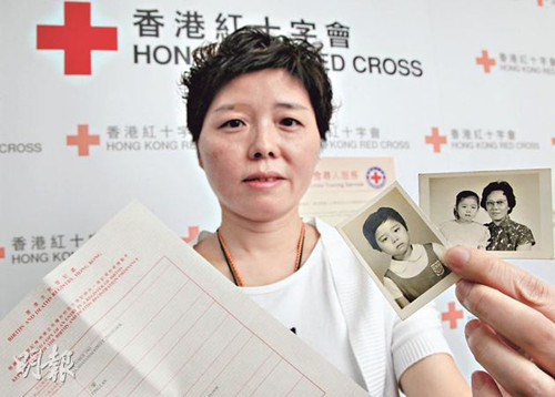 原名黄丁兰的陆女士(图)在儿时才获悉自己是领养孩子,但为免养母伤心一直不敢寻亲,至养母离世多年后,近日寻找其亲生父母,她手持的是童年时和养母的合照。香港《明报》图