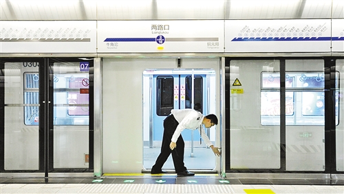 丰重阳在第一班列车运行前对站台安全门进行检查.