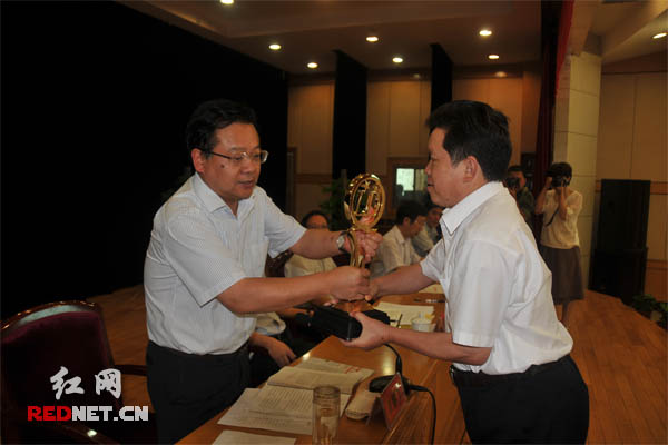 娄底市委书记、市长易鹏飞为获得首届市长质量奖的湖南九龙集团颁奖,集团执行总裁黄戈领奖。