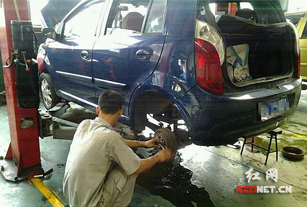 工作人员正在为一辆汽车更换轮胎。