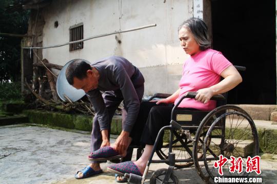 图为唐清理在帮妻子洗脚。 陈龙 摄