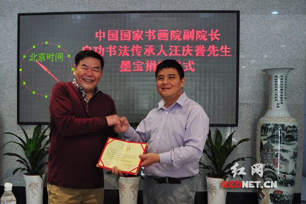 湖南省残疾人福利基金会理事长黄凤湘（左）为汪庆誉颁发荣誉证书。