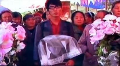 何滨捧着爱人遗像，送上深情一吻。视频截图