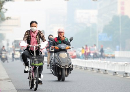 昨日下午,五一大道上,一名市民戴着口罩在雾霾中骑车。均为石祯专 陈飞 王志伟 摄影报道