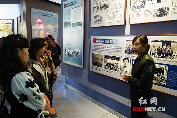 从全国各地来参加“江苏红色旅游行”的记者们在认真听讲解员介绍当年新四军军部在盐城重建后的战斗历程。