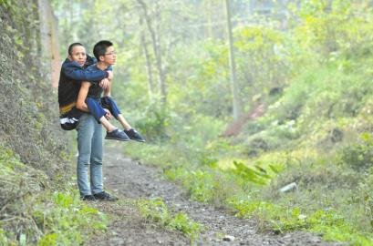 17岁男孩为照顾瘫痪父亲 背着爸爸上学