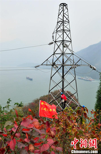 三峡库区秭归县电力公司“元成突击队”队员在青滩链子崖跨江塔上进行检查。雷勇 摄