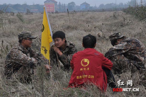 驼队成功跨越长江后，在附近一空旷草地进行暂时休整，驼工们坐在草地上开心闲聊，因为这是驼队首次走过高速路段。