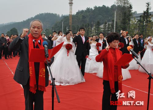 被誉为“中国第一幸福伉俪”的蒋含宇[左]、彭淑清夫妇带领100位新人在毛主席铜像前宣誓。