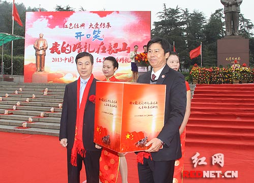 活动组委会副主任、湖南湘窖酒业有限公司副总经理凌湘发[左]将箴言箱交接给韶山毛泽东广场管理处处长张正山。