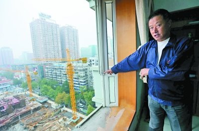 郑先生家的窗玻璃被吊车吊臂撞破。记者杨涛 摄