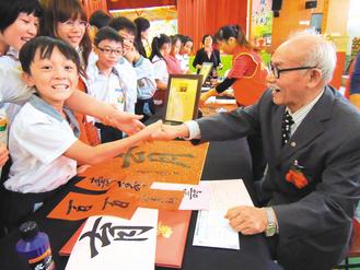 小学生和曾玺握手。图自台湾《联合报》