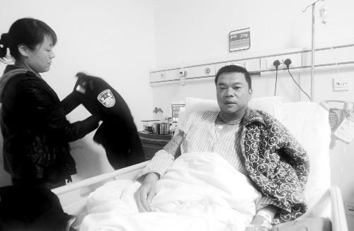 交警王建强目前仍呆在重症监护室里，妻子在为他整理警服。首席记者 陈晓东 摄影