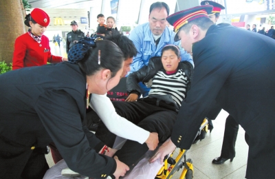 站内上非人员将临产的韩女士抬上担架。北京南站供图