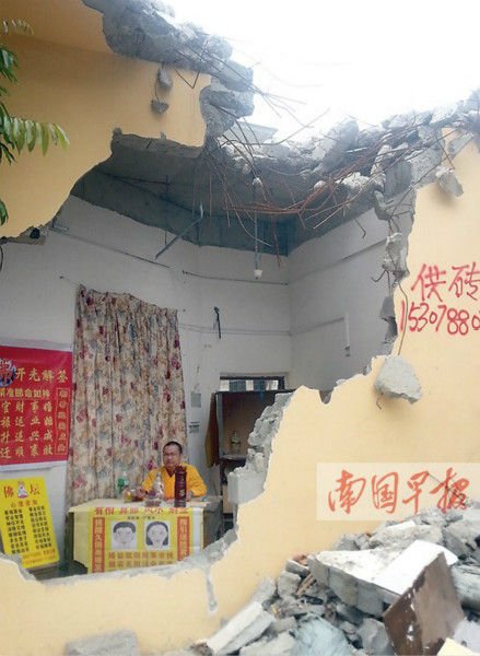 临街铺面被拆一半 男子稳坐其中为人算命(图)