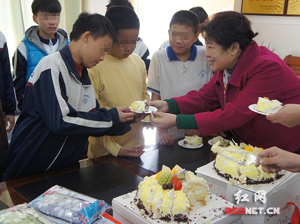 “爱心妈妈”孟繁英（右一）将一块块生日蛋糕送到孩子们的手中。